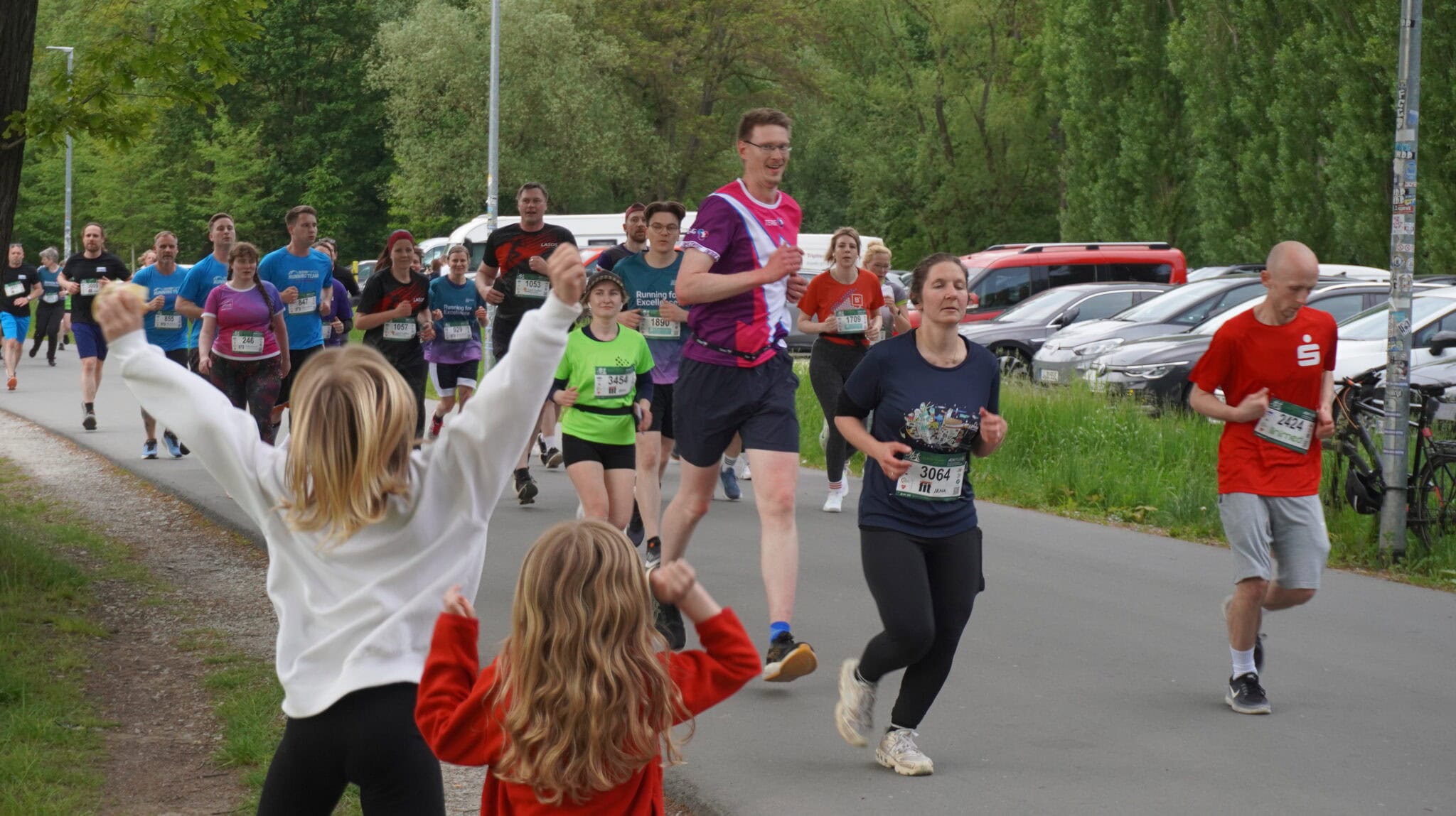 Läufer bei Stadtlauf, Kinder feuern an
